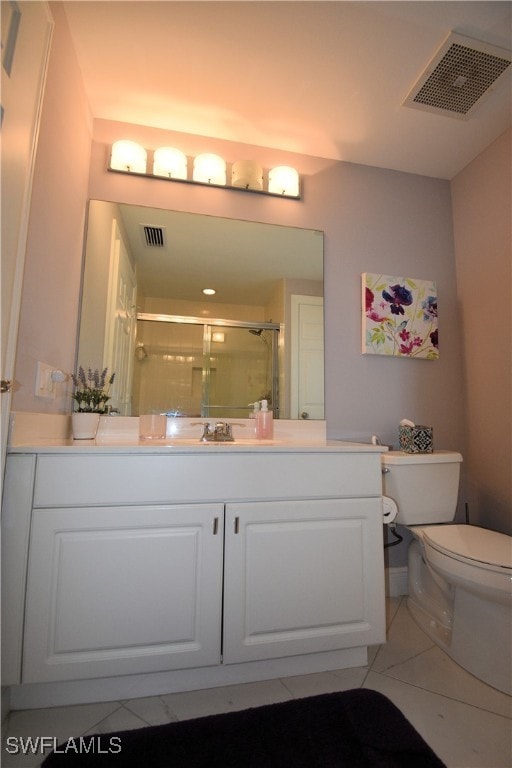 bathroom with tile patterned flooring, vanity, toilet, and a shower with door