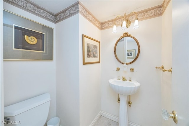 bathroom featuring tile patterned flooring, ornamental molding, and toilet