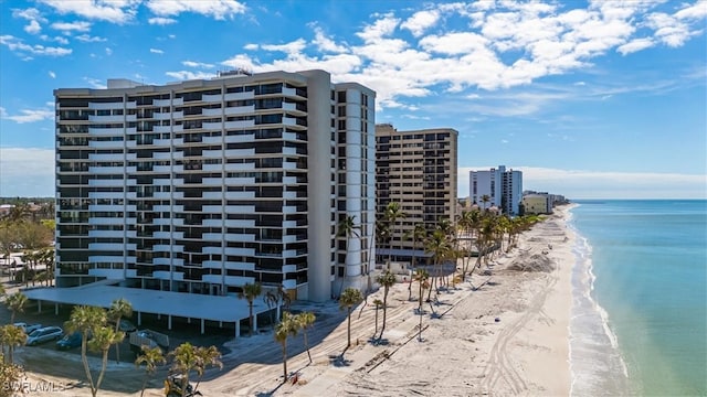 view of building exterior featuring a water view and a view of the beach