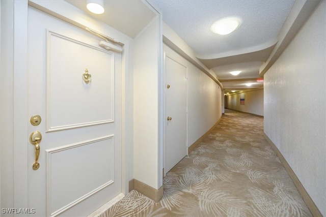 hall featuring a textured ceiling