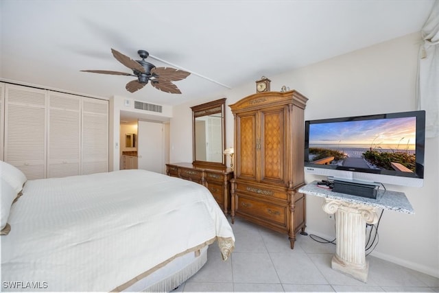 bedroom featuring ceiling fan, light tile patterned floors, and a closet