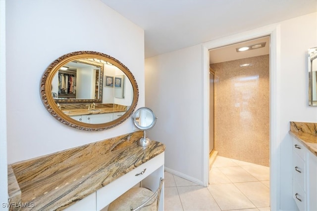 bathroom featuring tile patterned flooring, vanity, and walk in shower