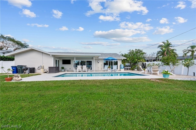 rear view of house featuring cooling unit, a yard, a fenced in pool, and a patio