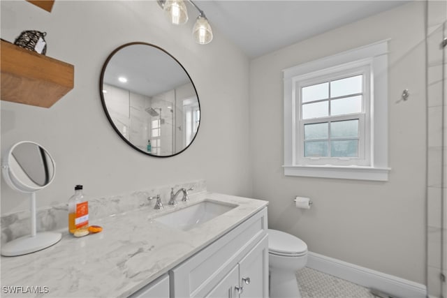 bathroom with vanity, toilet, and a shower