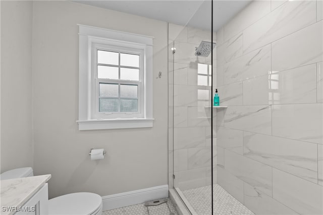 bathroom featuring vanity, tiled shower, and toilet