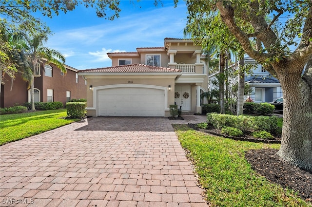 mediterranean / spanish-style home featuring a balcony, a front yard, and a garage