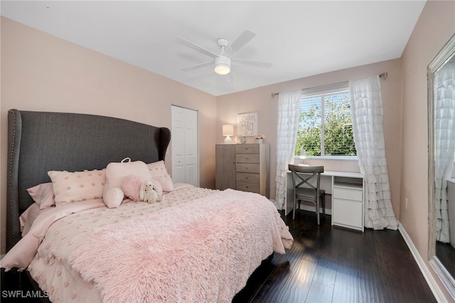 bedroom featuring dark wood-type flooring, ceiling fan, and a closet