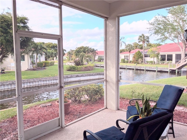 sunroom featuring a water view