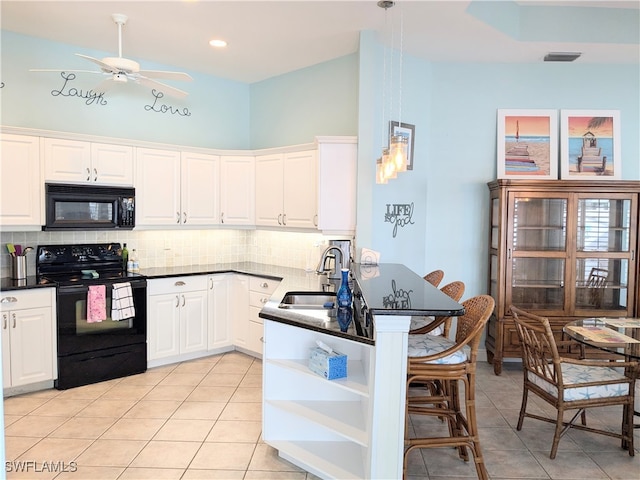 kitchen featuring a breakfast bar area, white cabinetry, and black appliances