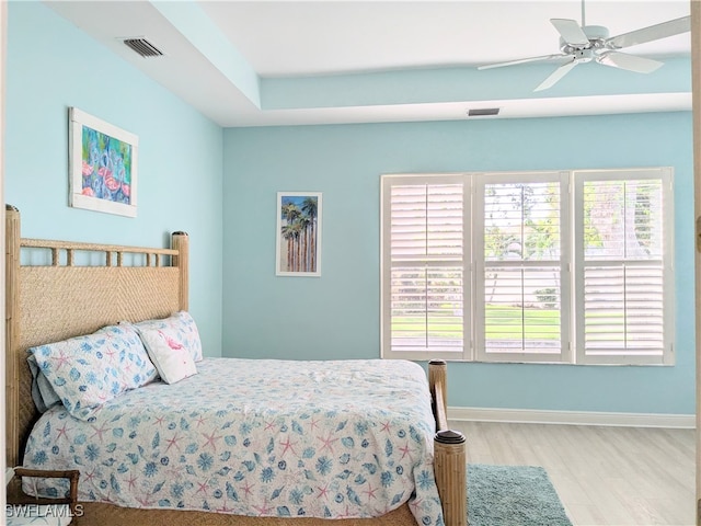 bedroom with multiple windows, ceiling fan, and light wood-type flooring