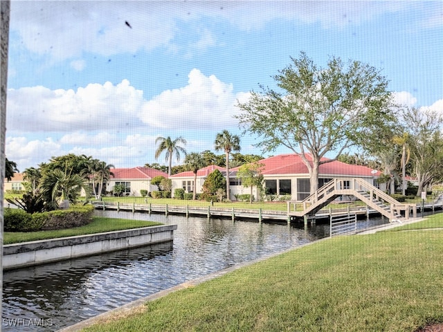 view of dock with a yard and a water view