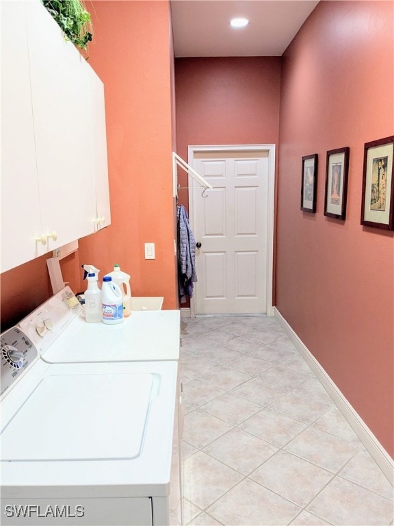 laundry area with cabinets, washer and clothes dryer, and light tile patterned flooring