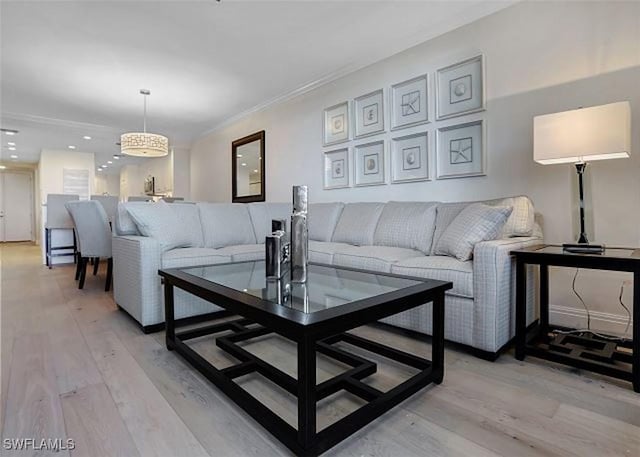 living room featuring crown molding and light hardwood / wood-style flooring