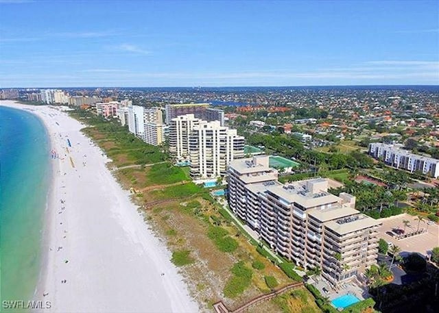 drone / aerial view with a water view and a beach view