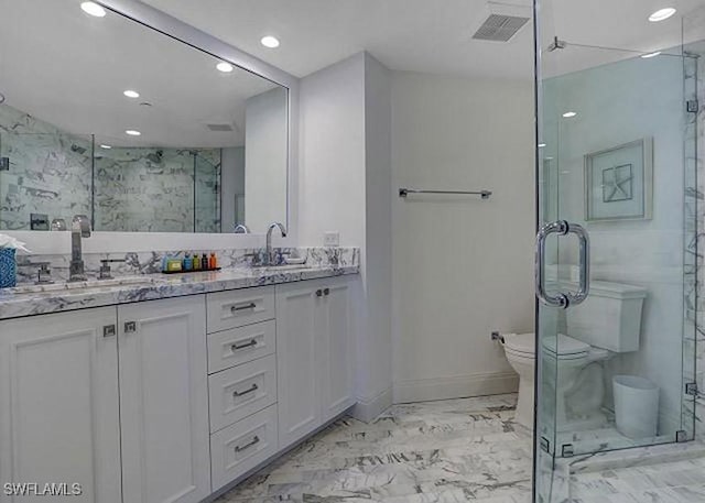 bathroom with a shower with door, vanity, and toilet