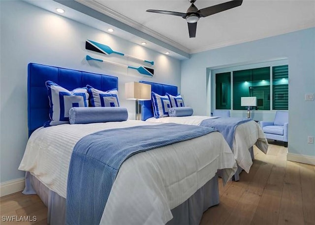 bedroom featuring hardwood / wood-style floors, ceiling fan, and crown molding