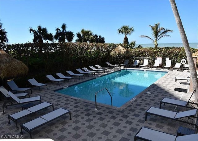 view of pool featuring a patio area and a water view