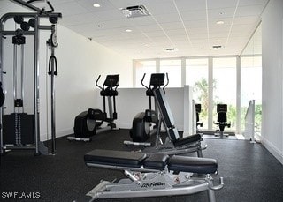 workout area featuring a drop ceiling and expansive windows