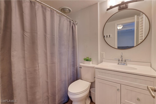 bathroom featuring vanity, toilet, and walk in shower