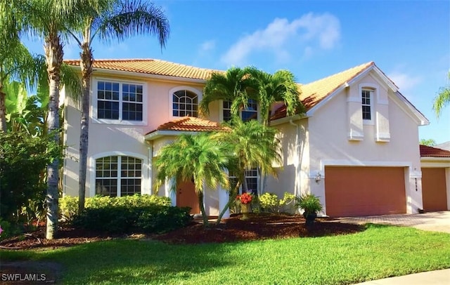 mediterranean / spanish house featuring a front lawn and a garage