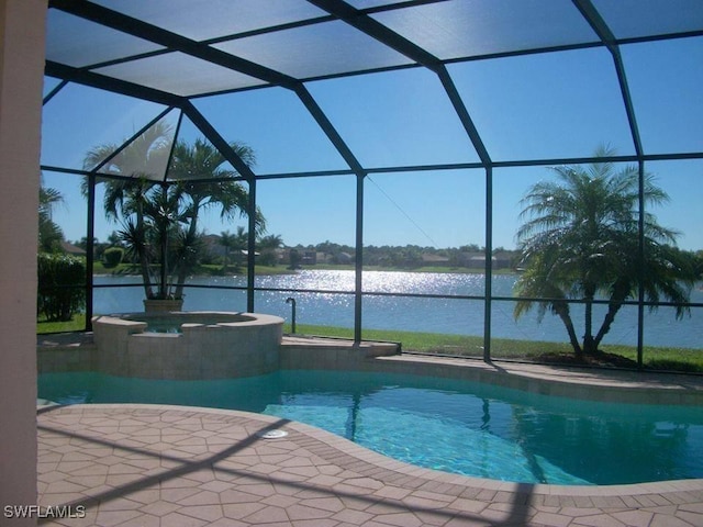 view of pool with a lanai, a patio, a water view, and an in ground hot tub