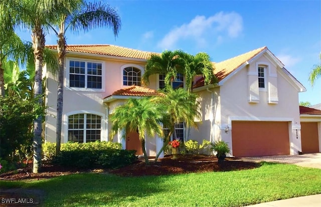 mediterranean / spanish-style house featuring a front yard and a garage