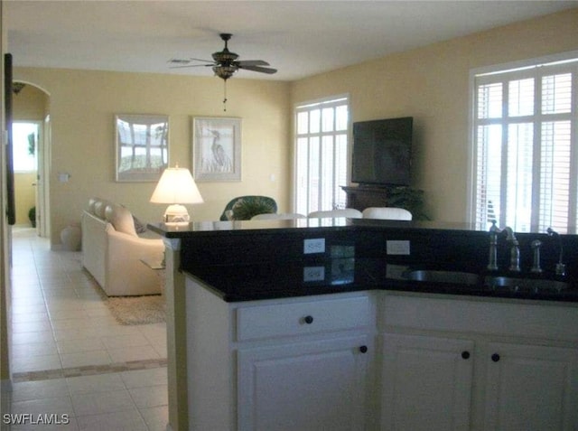 kitchen with sink, a healthy amount of sunlight, white cabinetry, and light tile patterned flooring