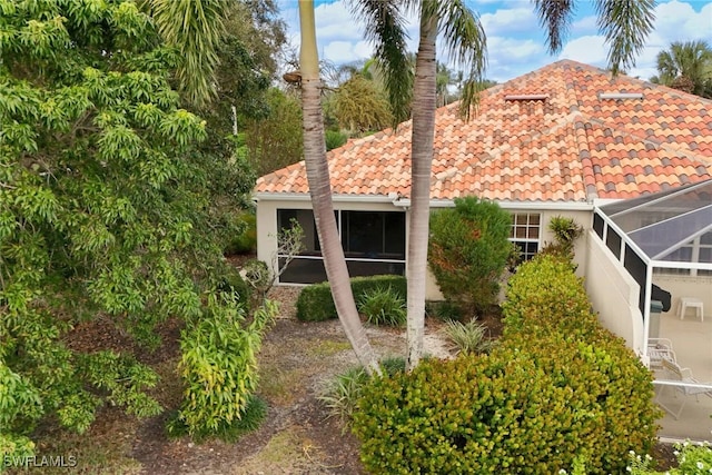 view of property exterior featuring glass enclosure