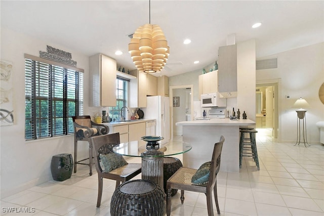 dining space featuring light tile patterned floors and sink