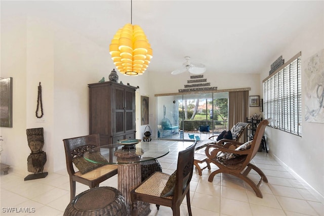 tiled dining area with ceiling fan with notable chandelier and vaulted ceiling