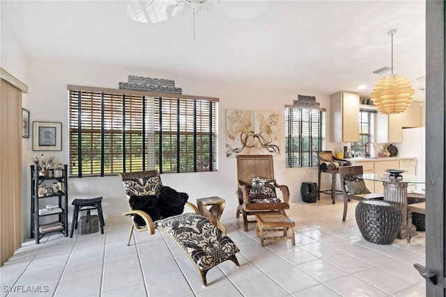 living area featuring ceiling fan, sink, a wealth of natural light, and light tile patterned flooring