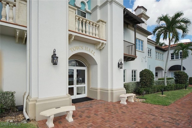 doorway to property with a balcony and french doors