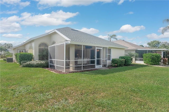 rear view of property with a lawn and central AC