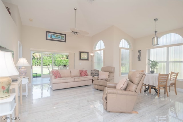 living room with ceiling fan and a high ceiling