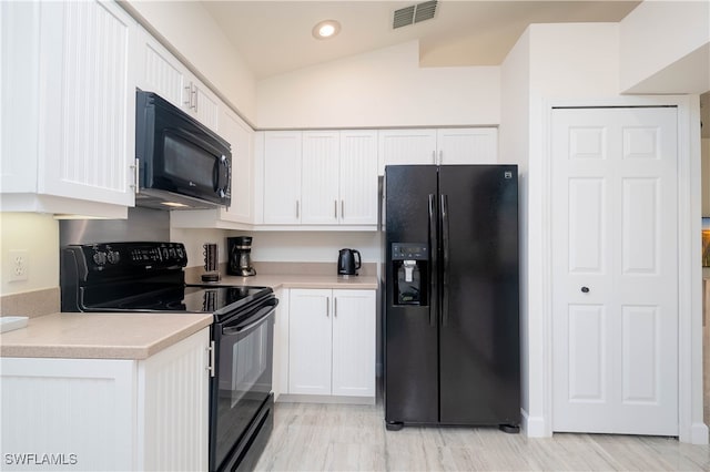 kitchen featuring white cabinets, black appliances, and vaulted ceiling