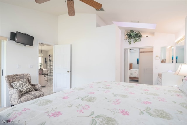 bedroom featuring vaulted ceiling with skylight, ceiling fan, and a closet