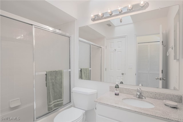 full bathroom featuring shower / bath combination with glass door, vanity, and toilet