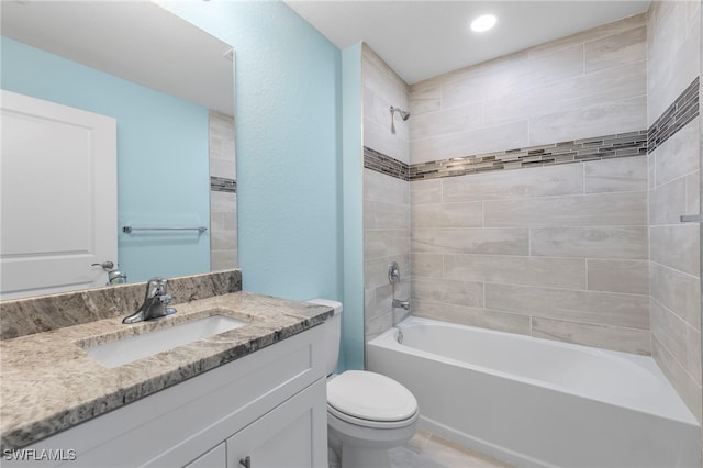 full bathroom featuring toilet, vanity, and tiled shower / bath