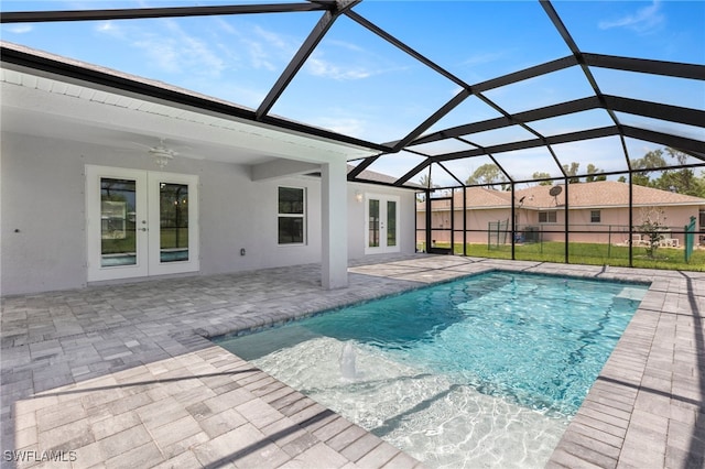 view of swimming pool featuring ceiling fan, a patio area, a lanai, and french doors