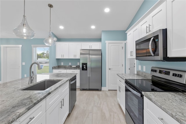 kitchen with sink, stainless steel appliances, light stone counters, white cabinets, and light wood-type flooring