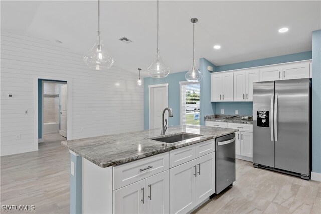 kitchen with white cabinets, pendant lighting, sink, and stainless steel appliances