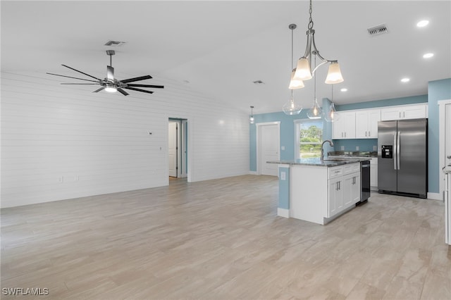 kitchen featuring hanging light fixtures, a center island with sink, white cabinets, and stainless steel appliances