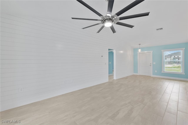 unfurnished room with ceiling fan, vaulted ceiling, and light wood-type flooring