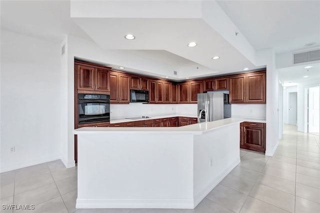 kitchen with an island with sink, light tile patterned floors, and black appliances