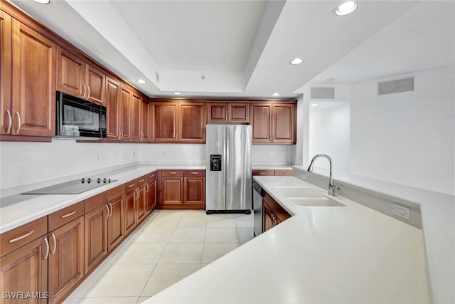 kitchen featuring black appliances, sink, a raised ceiling, and light tile patterned flooring