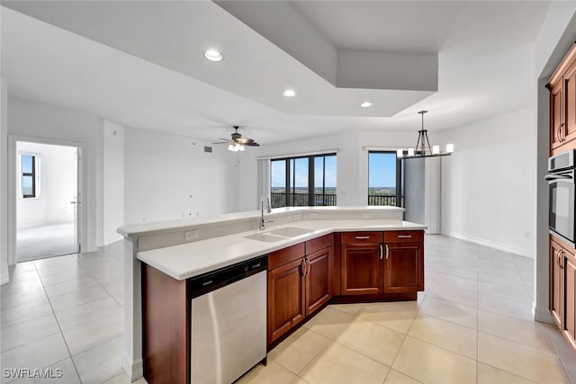 kitchen with stainless steel appliances, light tile patterned flooring, sink, ceiling fan with notable chandelier, and decorative light fixtures