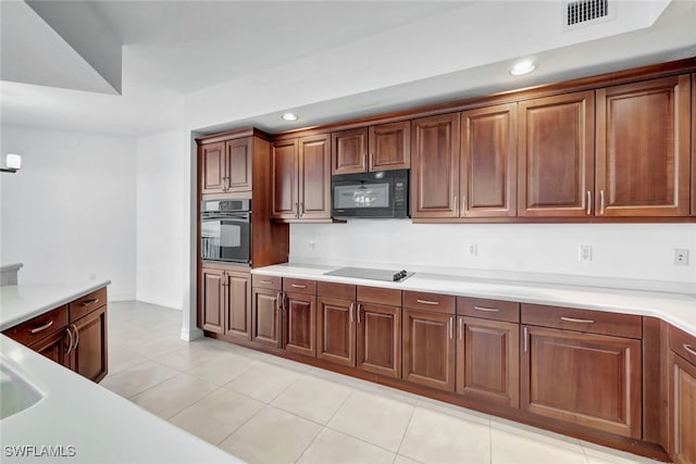 kitchen featuring light tile patterned flooring and black appliances