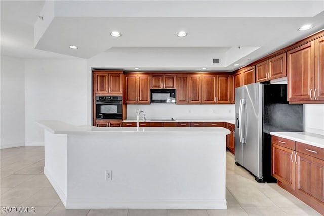 kitchen featuring a kitchen island with sink, black appliances, and light tile patterned floors