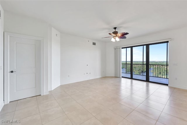 spare room featuring ceiling fan, light tile patterned floors, and a water view