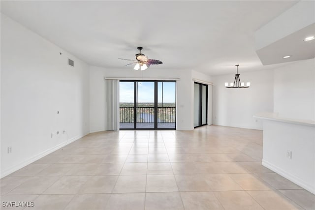 empty room with light tile patterned floors and ceiling fan with notable chandelier